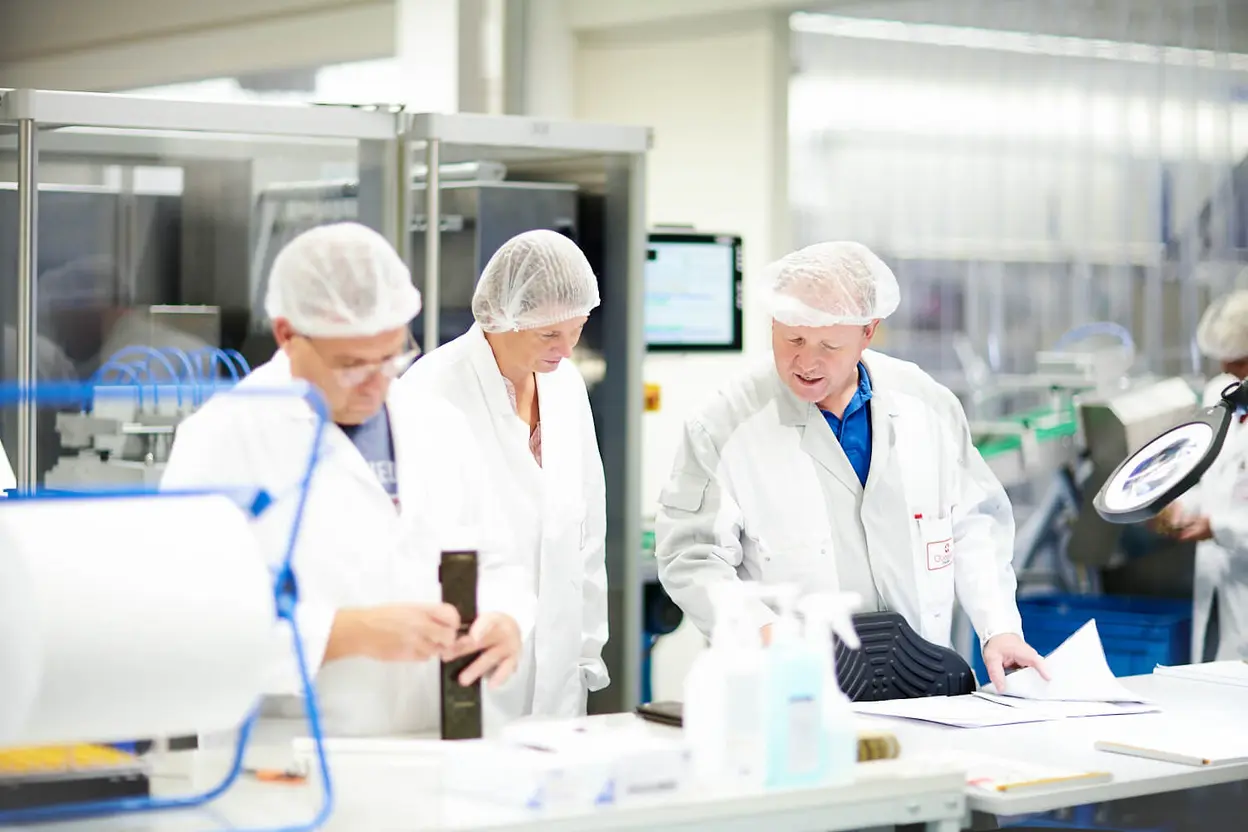 Drei Arbeiter*innen in der Produktion von Queisser Pharma